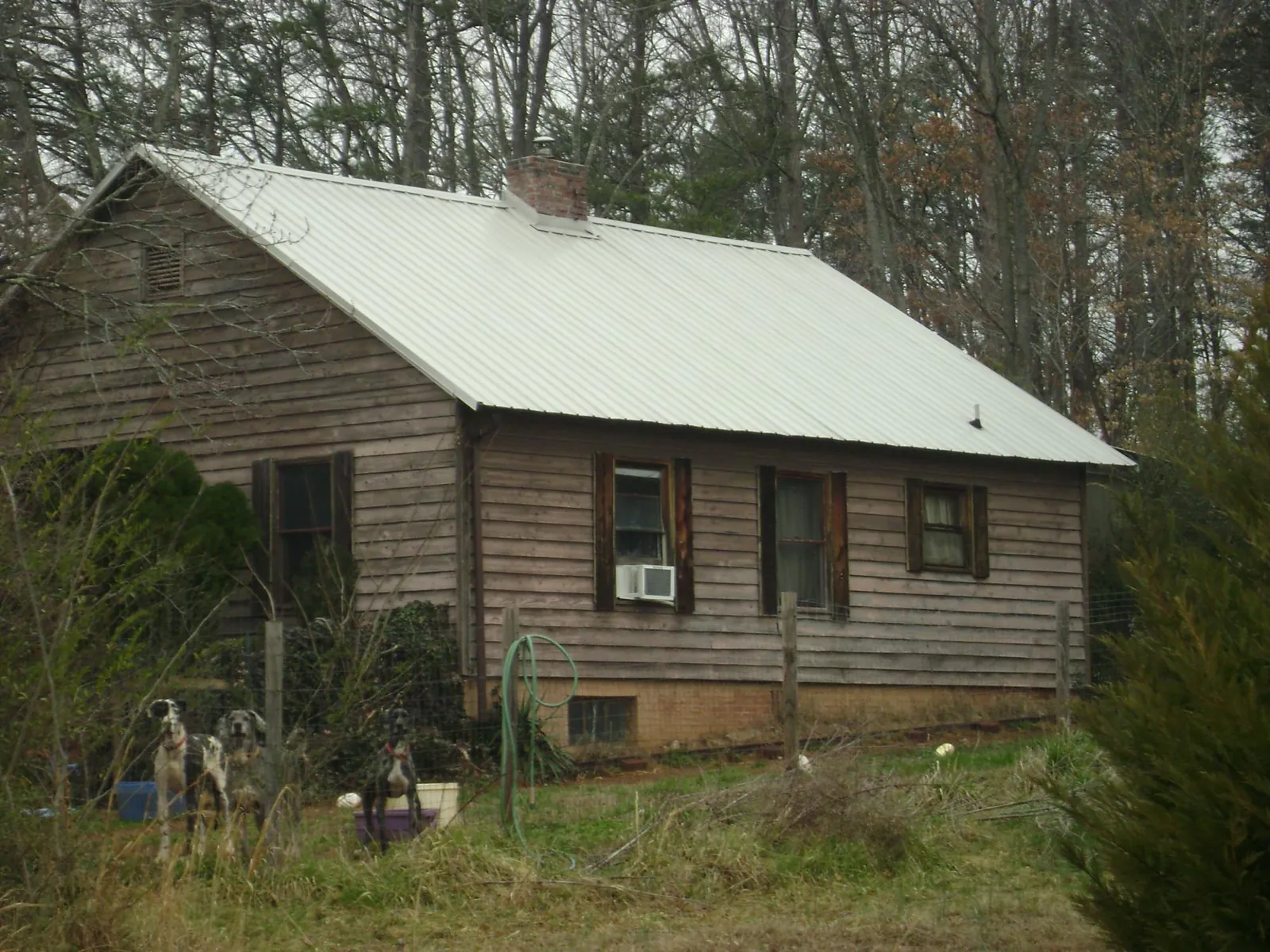 White metal roof on an old wood sided farmhouse, from a Metal Roof Installation job in Marathon
